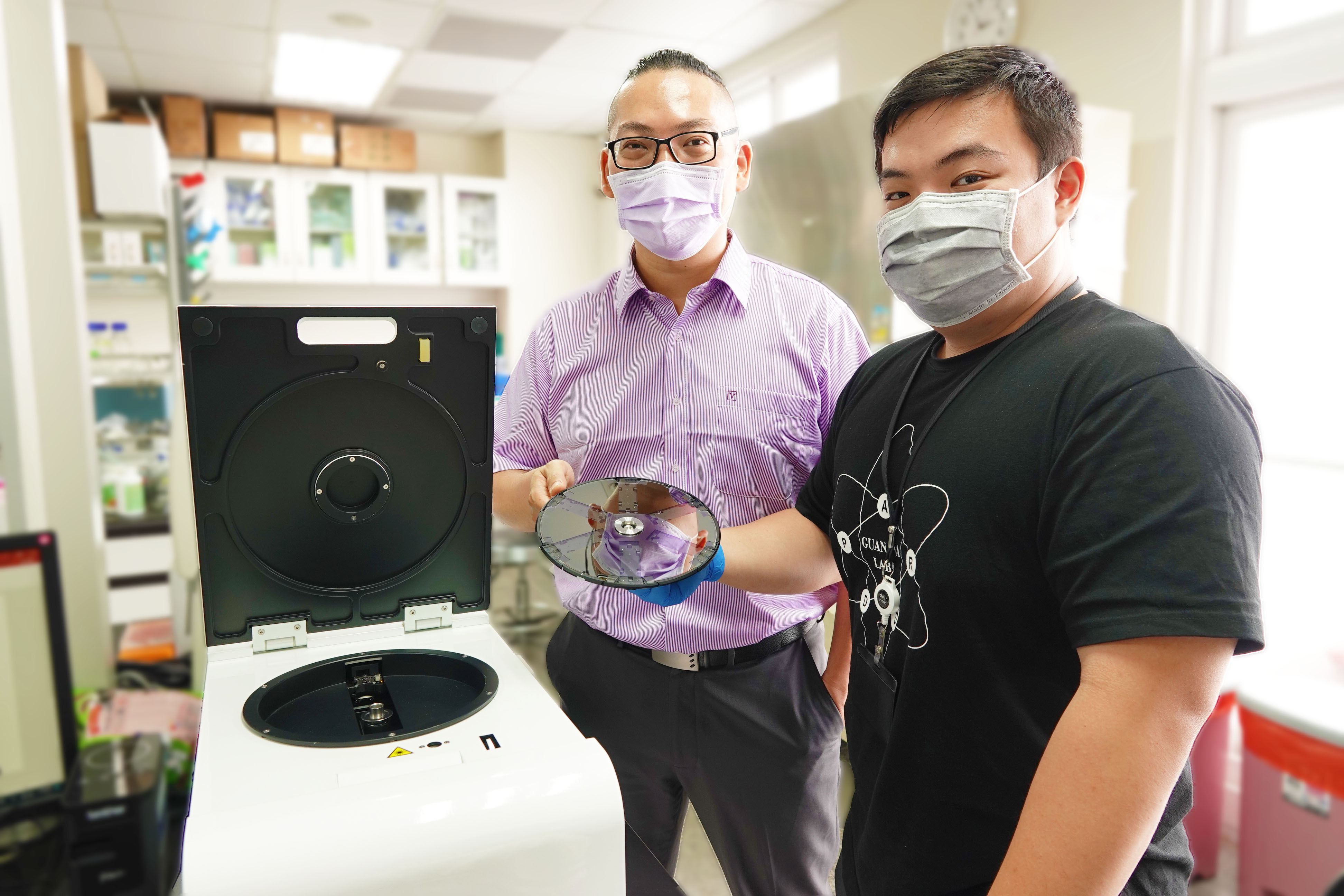 Professor Guan-Da Syu (left) and student demonstrate use of the chip scanner